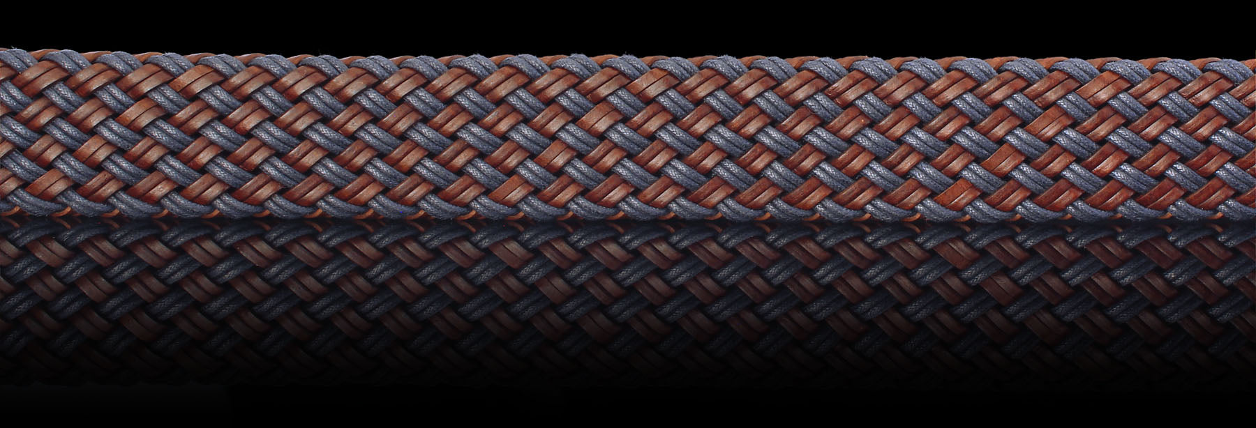 Brown and blue braided genuine leather belt closeup on black background