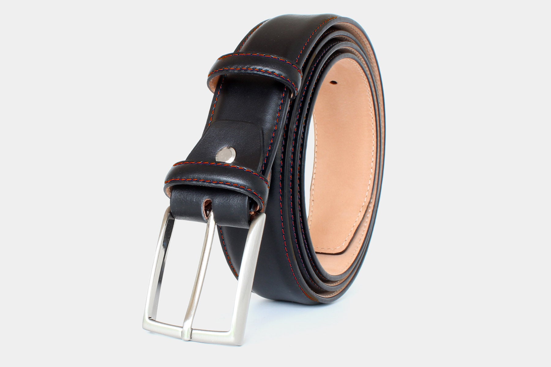 Close-up men’s black calfskin Italian leather belt with solid brass buckle and red stitched edge. Handmade in Italy.
