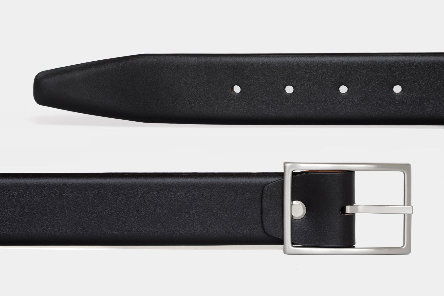 Close up of women's black soft Italian calfskin leather belt with a feather edge finish and slim silver buckle.