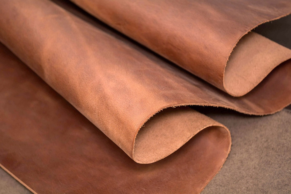 Natural vegetable-tanned Italian leather hides, showing sustainable tanning practices.