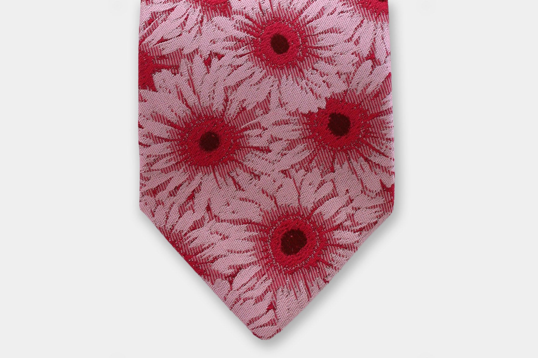 Close-up of a Robert Charles gerbera pink silk tie showcasing the artisan Italian intricate weave.