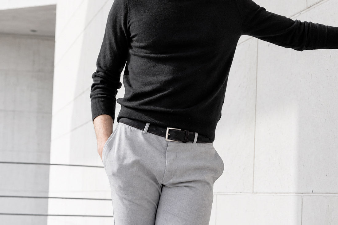 Men’s black suede belt with brushed silver buckle styled with a black jumper and light grey trousers