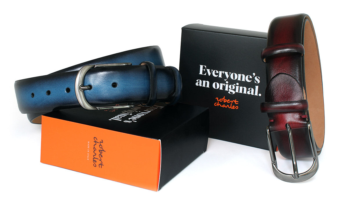 Handpainted men’s belts with polished gunmetal buckles, handmade in Italy displayed with Robert Charles gift box 
