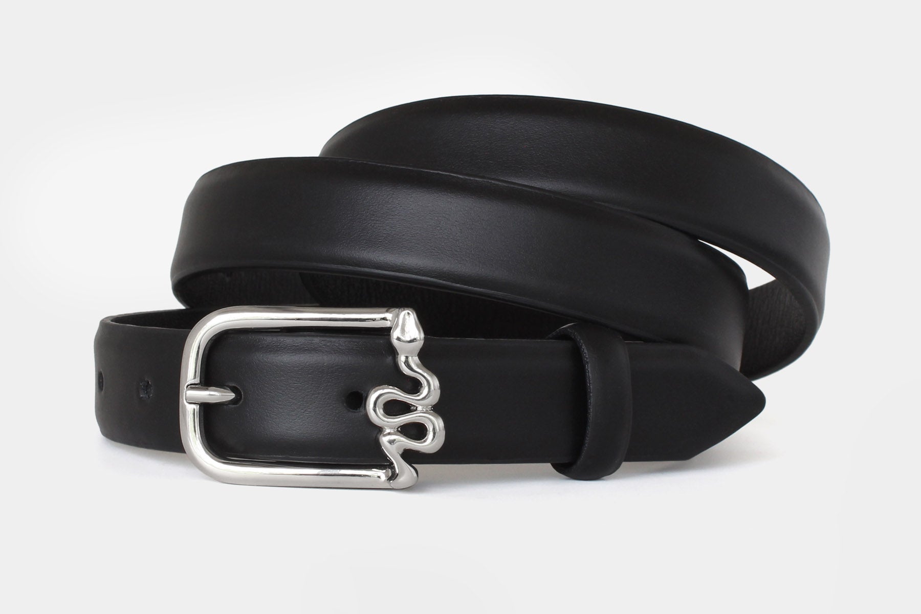 Closeup of women’s black slim Italian calfskin leather belt with silver serpentine buckle.