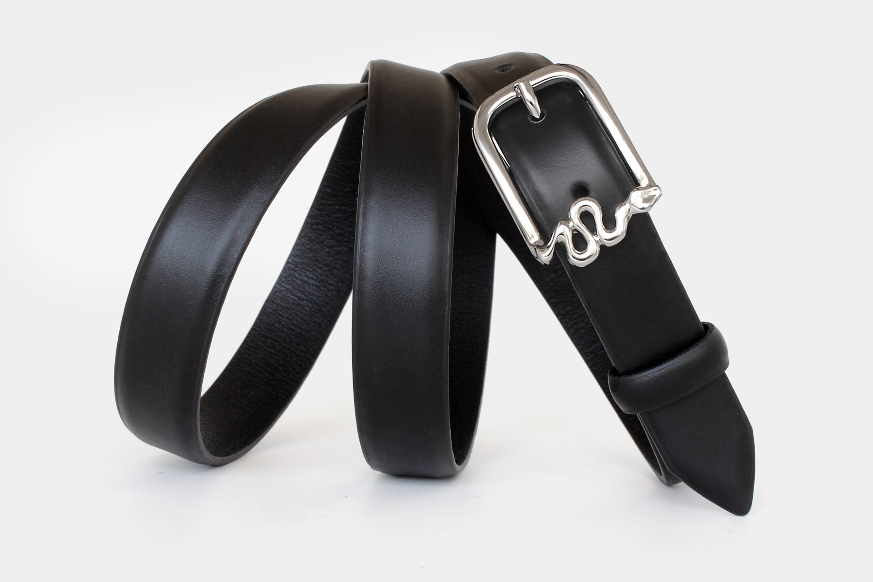 Women’s black slim Italian calfskin leather belt with silver serpentine buckle and  feather edge finish.