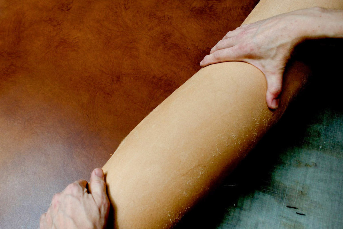 Leather artisan craftsman shaping premium Italian leather for belt production