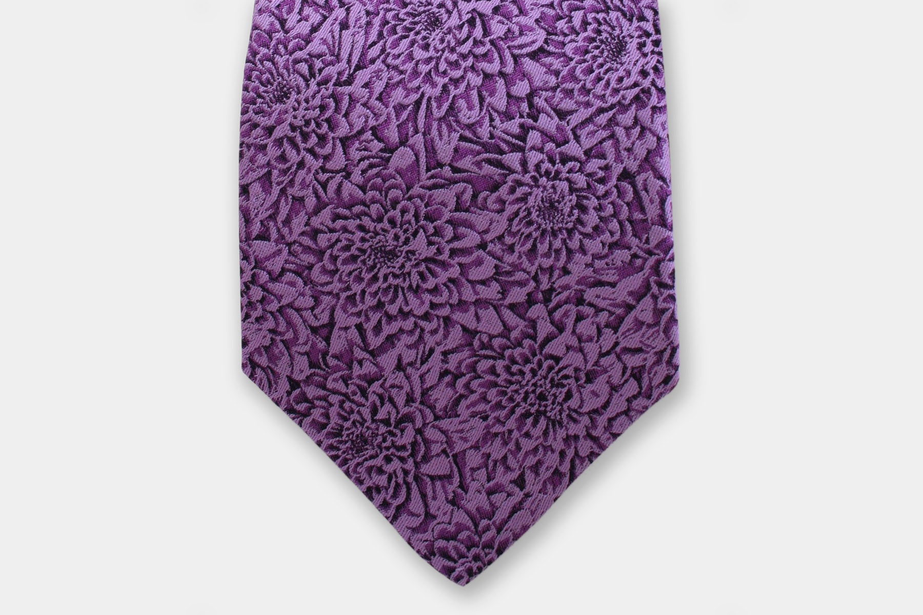 Close-up of a Robert Charles chrysanthemum purple silk tie showcasing the fine Italian intricate weave.