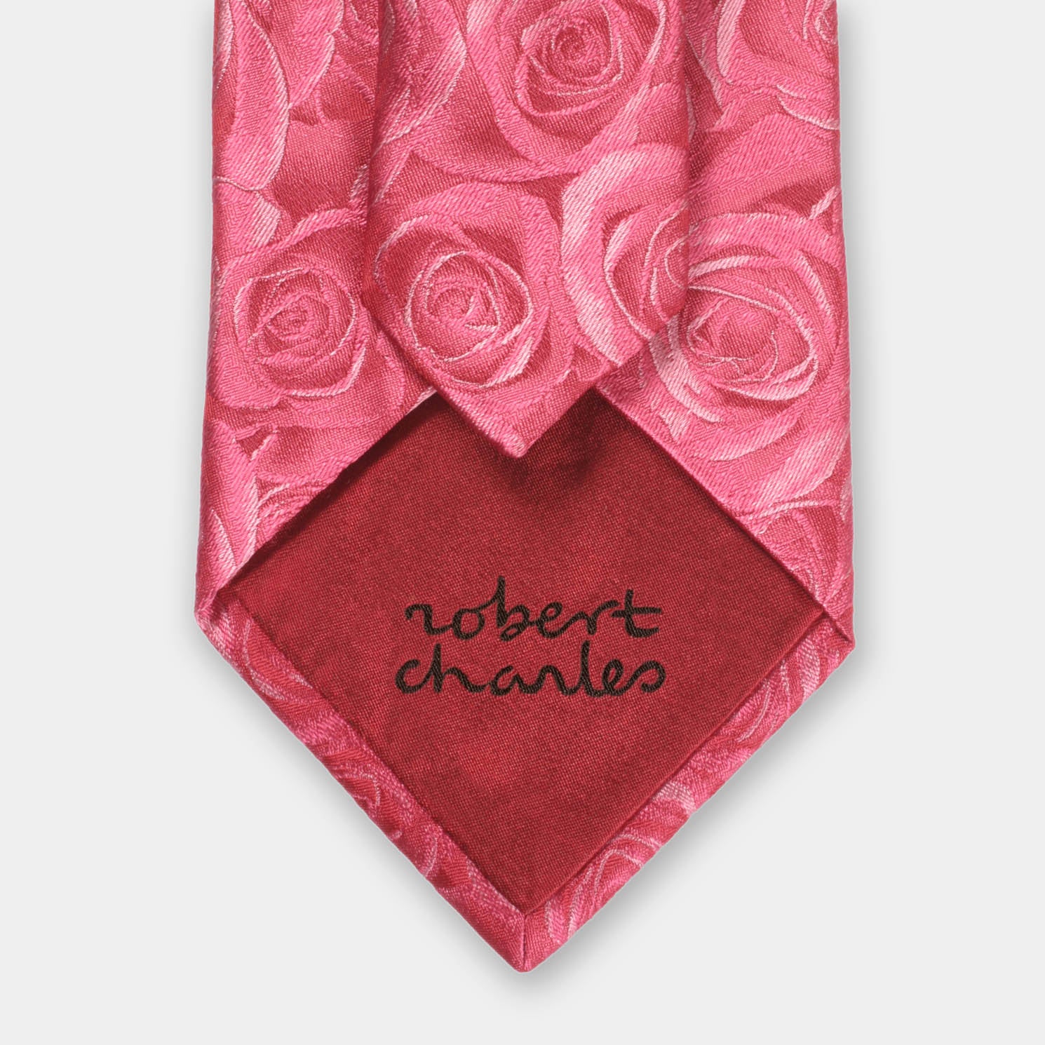 Close-up of a Robert Charles rose pink silk tie highlighting the fine Italian craftsmanship and intricate weave.